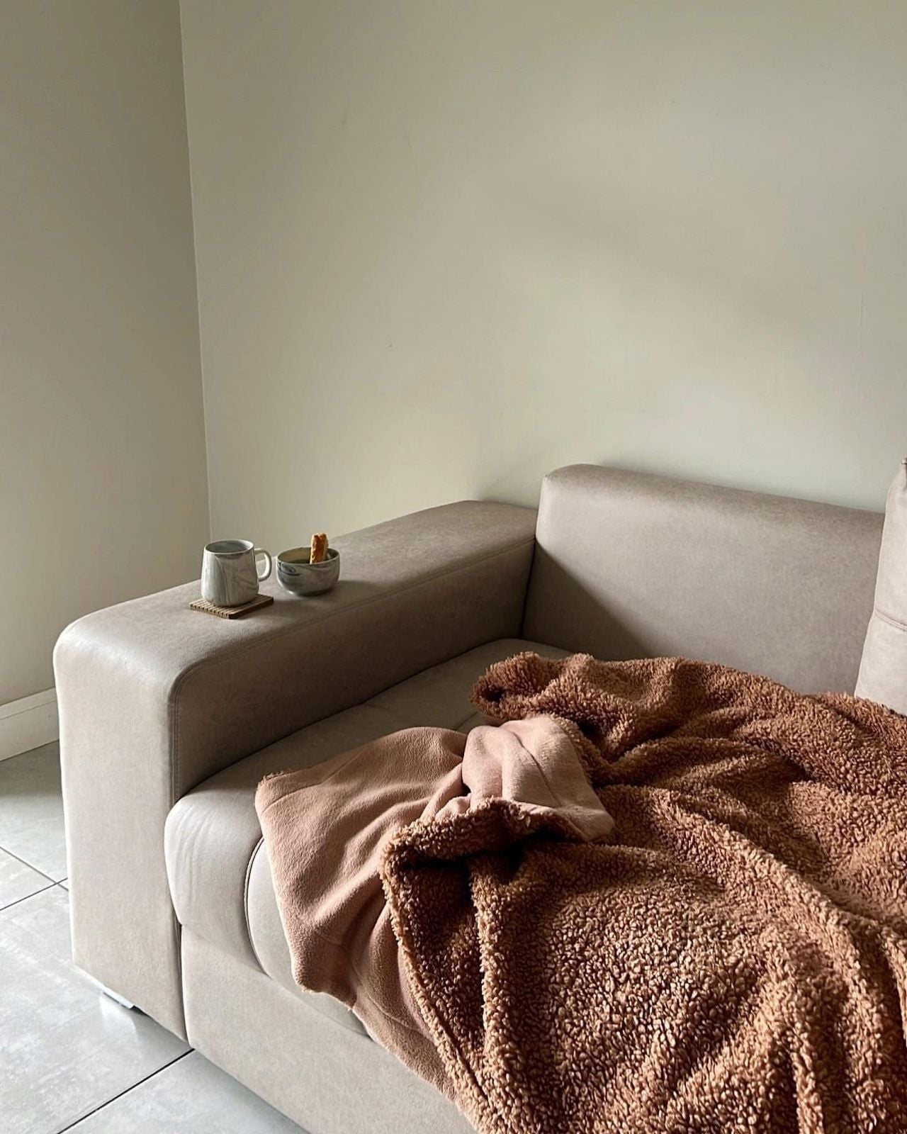 Cosy handcrafted Noli blanket draped on a sofa